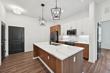A kitchen with a white countertop and wooden cabinets.